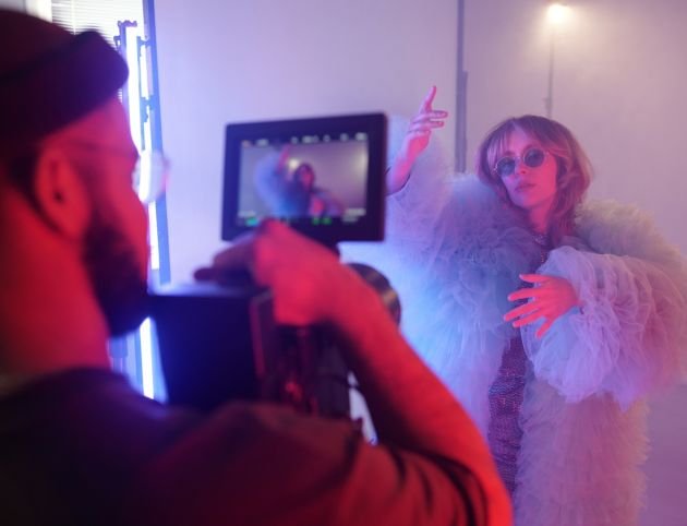 Backstage Process of Woman Performing For Camera Backstage process of actress performing for camera in dramatic costume while director films scene during studio shoot